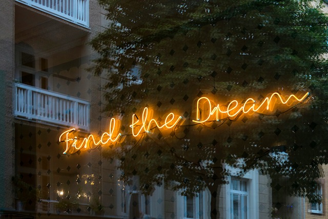 A neon sign with the words Find the Dream